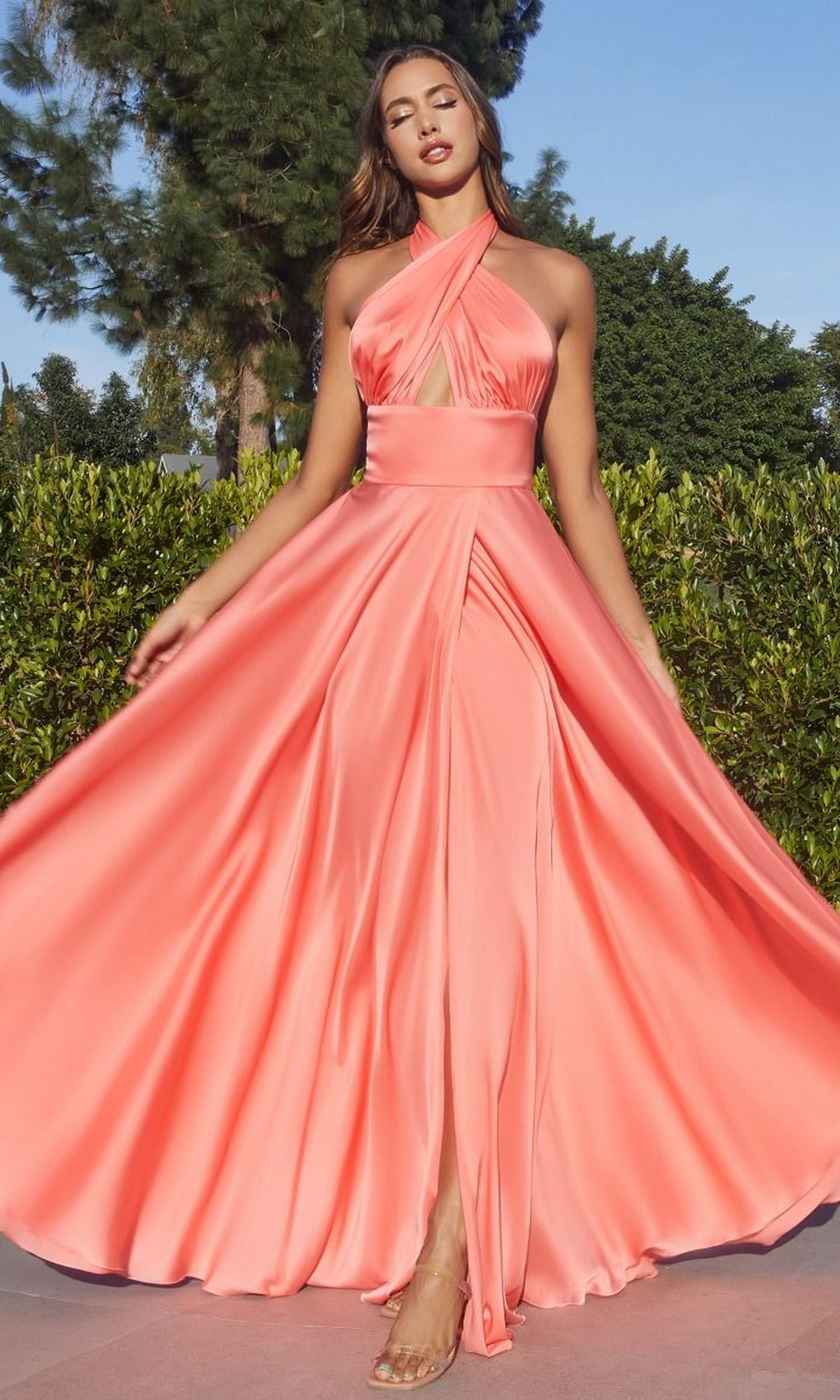 A woman stands outdoors in a Ladivine CD323 Long Infinity Prom Dress with Slit, surrounded by greenery and trees.